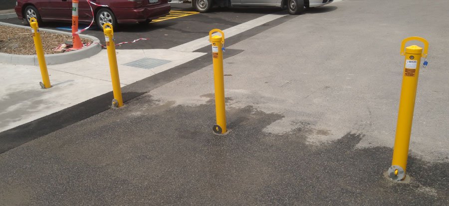 A row of key-lockable removable bollards beside the car park at Ringwood North Primary School