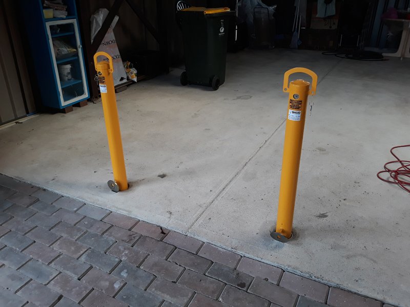 Close view of the Sunshine garage bollards with the paved driveway in front