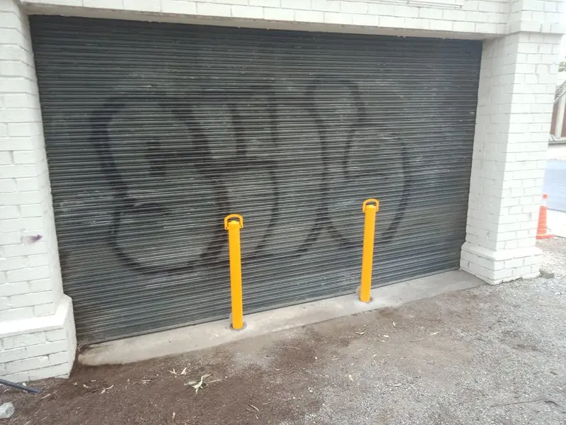 Two removable bollards in front of a roller door at BWS Eltham