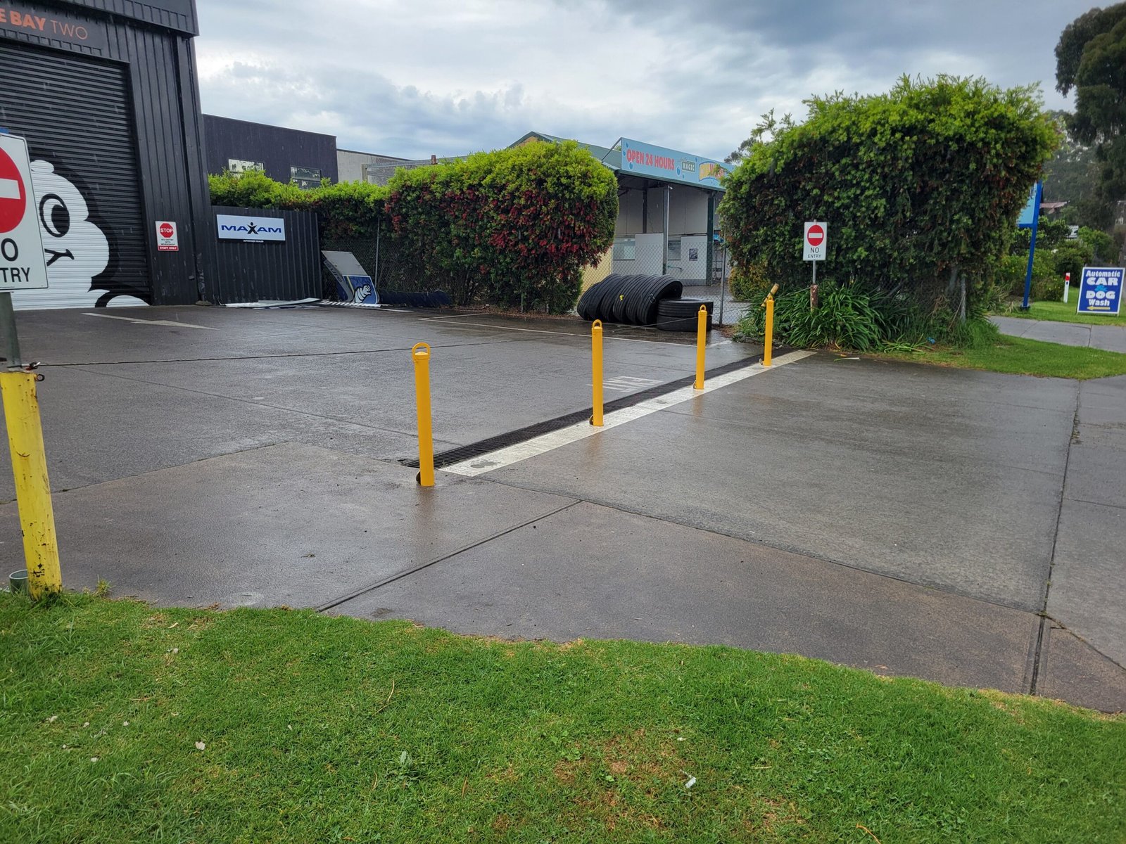 Yellow removable bollards across the driveway beside the workshop at Fast Freddies in Healesville.