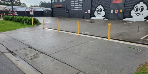 Wide view of Fast Freddies Tyre Service and the yellow bollards across its frontage.