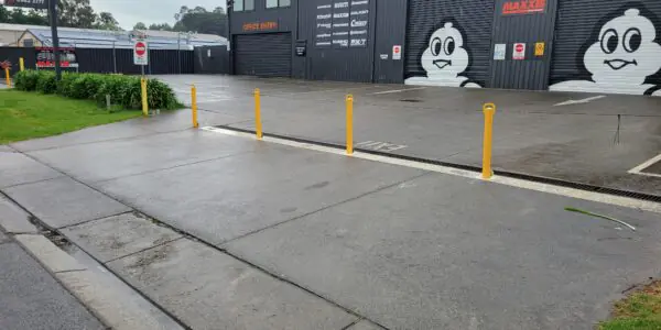 Wide view of Fast Freddies Tyre Service and the yellow bollards across its frontage.